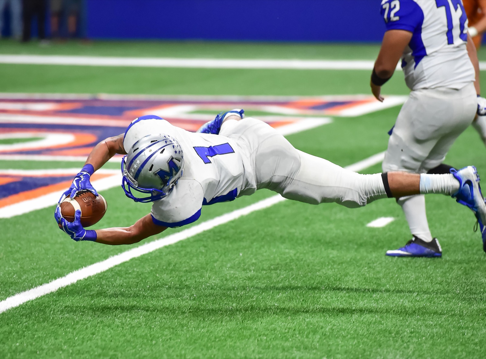 A receiver fully extended, diving to secure a catch